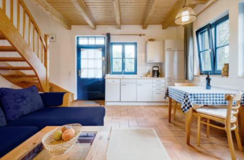 2-Raum Apartment bis 4 Pers 32 في Rankwitz: غرفة معيشة مع أريكة زرقاء وطاولة