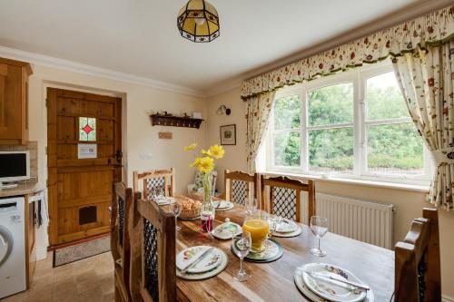 a dining room with a table and a window at Oak Tree Cottage, Charming, Rural New Forest Home in Boldre