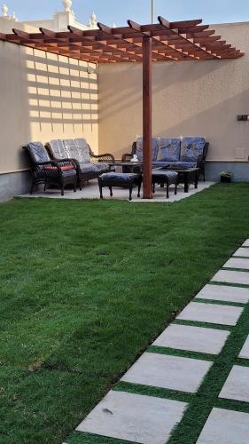 a group of benches sitting under a pergola at شاليه المنى - الخبر - للعائلات in Al Khobar