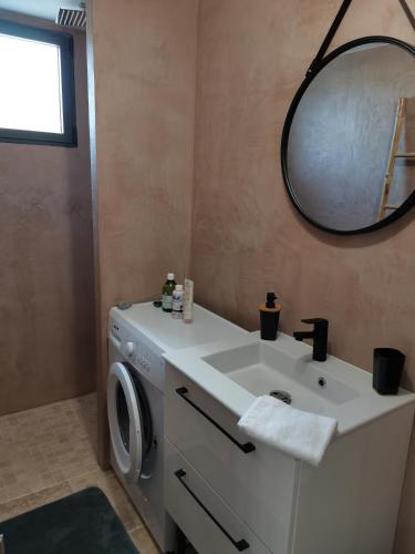 une salle de bain avec un lavabo et une machine à laver dans l'établissement Studio en campagne, à Avignon