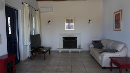a living room with a couch and a fireplace at Kukuwaia in Almirida