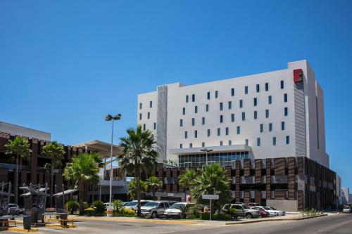a large white building with cars parked in a parking lot at Fiesta Inn Los Mochis in Los Mochis