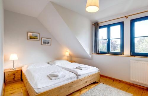a white bedroom with a bed and windows at 4-Raum Apartment bis 8 Pers 43 in Rankwitz