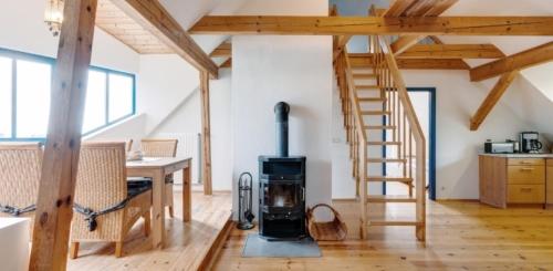 a wood stove in a room with a staircase at 3-Raum Dachgeschoss Apartment 54 in Rankwitz