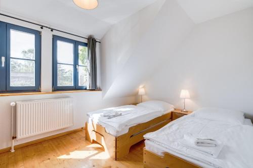 two beds in a room with two windows at 4-Raum Apartment bis 8 Pers 41 in Rankwitz