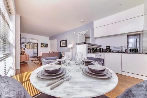 een eetkamer en een keuken met een tafel en stoelen bij Interior-Designer Apartment with 2 TERRACES in Londen