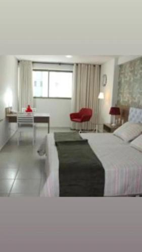a hotel room with a large bed and a desk at Betel Flat Executive Praia Boa Viagem in Recife