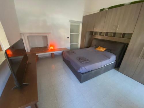 een kleine slaapkamer met een bed en een televisie bij Davide's House in Lomagna