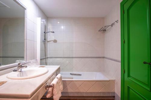 uma casa de banho com um lavatório e uma banheira em Hotel Doña Matilde em Estepona