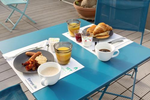 a blue table with two plates of food and drinks at Campanile Toulon - La Seyne sur Mer - Sanary in Six-Fours-les-Plages