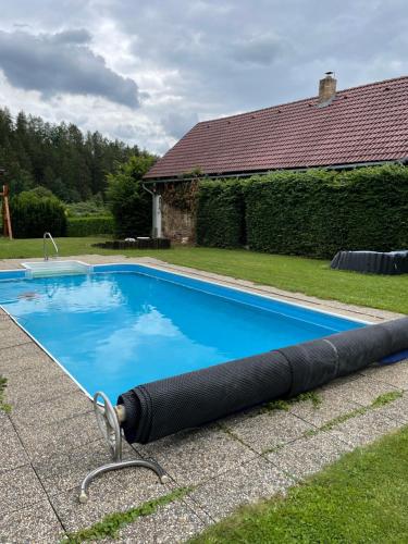 a swimming pool with a large water hose next to a house at Apartmán Beruška in Křelovice