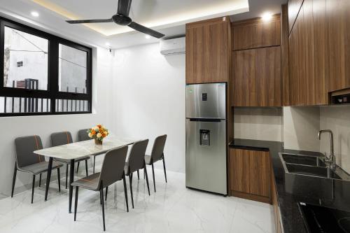 a kitchen with a table and chairs and a refrigerator at Ami House 1 in Hanoi