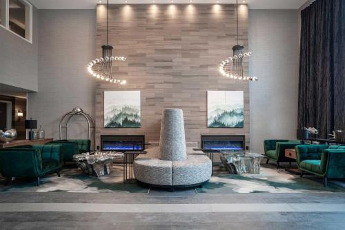 a lobby with green chairs and a fireplace at Sandman Signature St. John's Hotel in St. John's