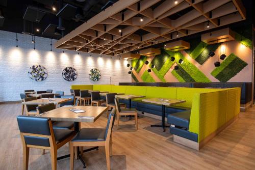 a restaurant with tables and chairs and a green wall at Sandman Signature St. John's Hotel in St. John's