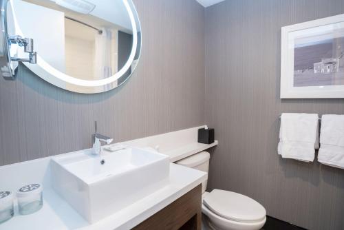 a bathroom with a white sink and a mirror at Sandman Signature St. John's Hotel in St. John's