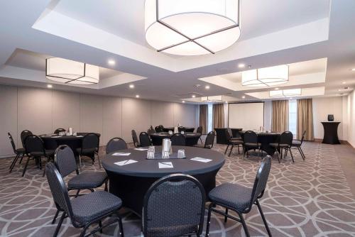 a conference room with tables and chairs and a chandelier at Sandman Signature St. John's Hotel in St. John's