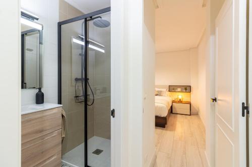 1 dormitorio y baño con ducha. en Apartamento PLAYA12, en Gijón