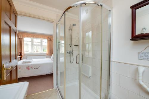 a bathroom with a shower and a bed at Oak Tree Cottage, Charming, Rural New Forest Home in Boldre