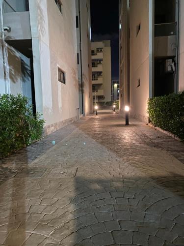 an empty street at night with lights on the side of a building at Chalet at Grand Hills Village - ONLY For Family in El Hamam