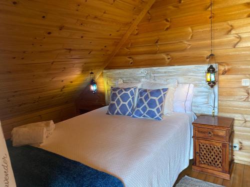 een slaapkamer met een bed in een houten hut bij Chalé 21 in Cortes do Meio