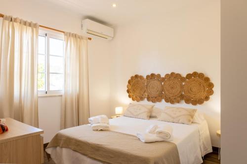 Un dormitorio blanco con una cama con toallas. en Casa da Lota, en Manta Rota