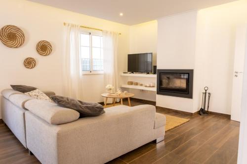 a living room with a couch and a fireplace at Casa da Lota, by Casas do Verão in Manta Rota