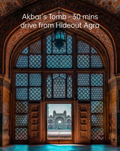 a view of a building through a large window at The Hideout Agra - Garden Homestay near Taj in Agra