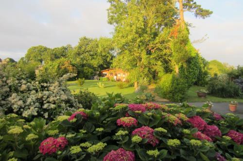 einen Garten mit Blumen und ein Haus im Hintergrund in der Unterkunft Gîte - Chambre d Hôtes Les 4 vents Guingamp in Saint-Agathon