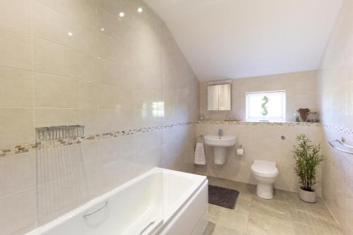een badkamer met een bad, een toilet en een wastafel bij Arran View Apartment at Heads of Ayr in Ayr