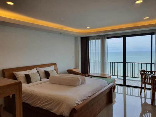 sypialnia z dużym łóżkiem i balkonem w obiekcie Grace Seaview บ้านพักส่วนตัว 3 ห้องนอน วิวทะเล หาดพลา w mieście Ban Phala