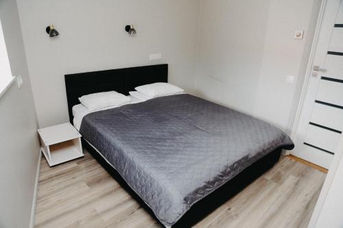 a bedroom with a bed in a white room at Hotel Vesiroos in Pärnu