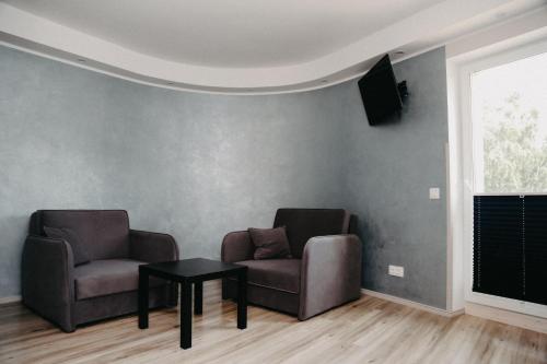 two chairs and a table in a living room at Hotel Vesiroos in Pärnu