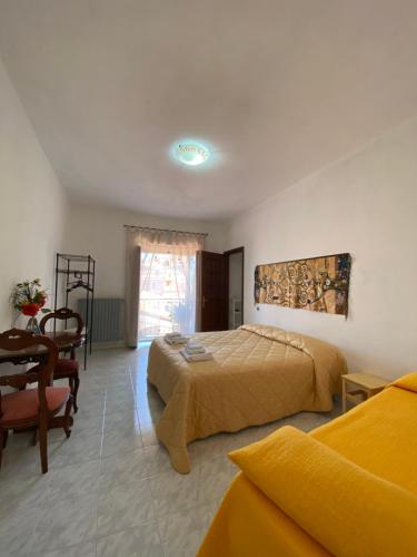a bedroom with a bed and a table and a chair at La Finestra Sui Cento Portali in Pignola