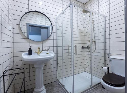 a bathroom with a sink and a shower with a mirror at Sleep in Centre - Aveiro in Aveiro