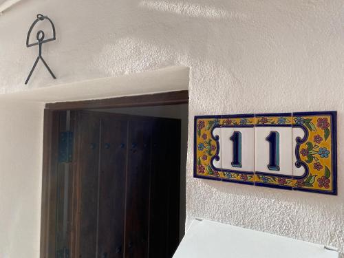 un cartel con el número 11 colgado en una pared en Apartamentos Indalo a los pies del Albaicín, en Granada