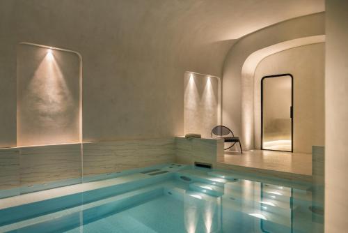 a swimming pool in a room with a mirror at Pavillon Faubourg Saint-Germain & Spa in Paris