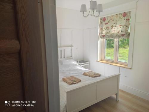 a bedroom with a bed with a window and two towels at The Wild Farm Lodge in Mullingar