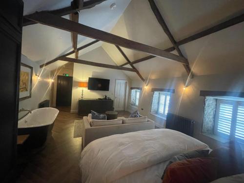 a bedroom with a bed and a couch and a tv at The Hideaway in Saint Brides Major