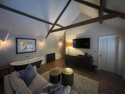 a large living room with a tub and a tv at The Hideaway in Saint Brides Major