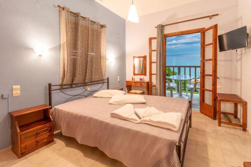 a bedroom with a bed with a view of the ocean at Kyma Papa Nero Studios in Agios Ioannis Pelio