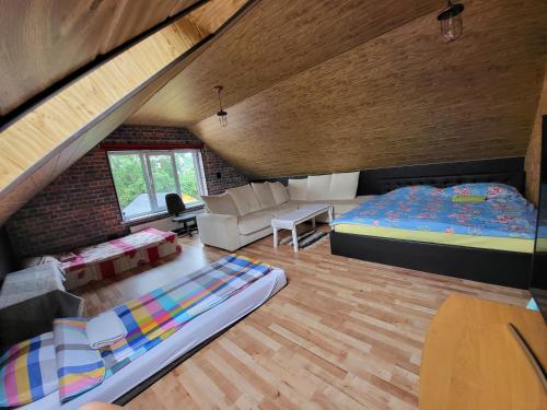 a attic room with two beds and a couch at Voodikoht Viljandis in Viljandi