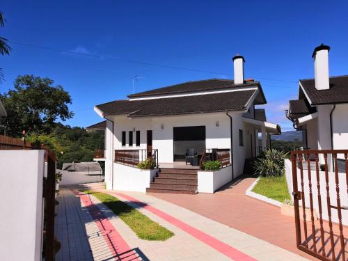 a white house with a gate and a driveway at Casa de Agrelos in Ponte da Barca
