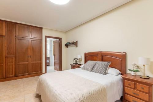 ein Schlafzimmer mit einem großen Bett und Holzschränken in der Unterkunft Caserío entre Bilbao y Urdaibai in Morga