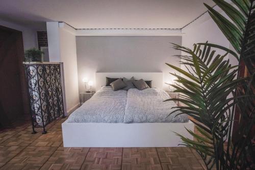 een slaapkamer met een wit bed met een plant bij Ferienwohnung Heidis Heidehaus in Schneverdingen