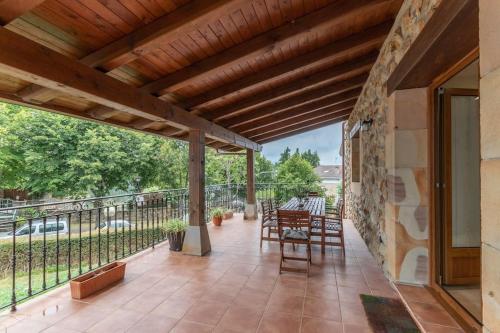 eine Terrasse mit einem Tisch und Stühlen auf dem Balkon in der Unterkunft Caserío entre Bilbao y Urdaibai in Morga