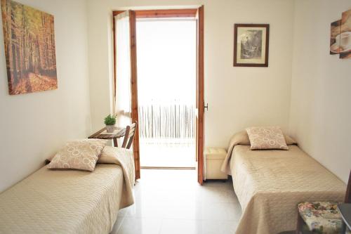 - 2 lits dans une chambre avec une porte ouverte dans l'établissement Casa Vacanze San Gregorio Magno, à San Gregorio Magno