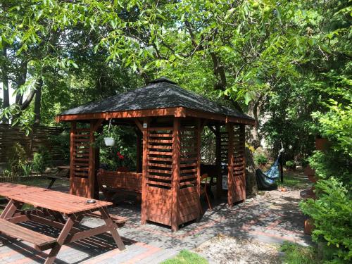 einen hölzernen Pavillon mit einem Tisch und einem Picknicktisch in der Unterkunft Tatamka Hostel in Warschau