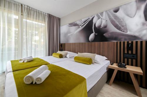 a bedroom with a large bed with towels on it at Residence Garden Istra Plava Laguna in Umag