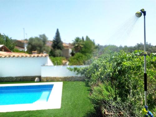 a swimming pool in a yard next to a house at Casa rural El Olivo in Aracena