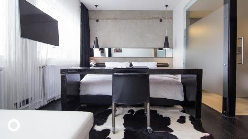 a bedroom with a bed with a desk and a chair at Thingholt by Center Hotels in Reykjavík